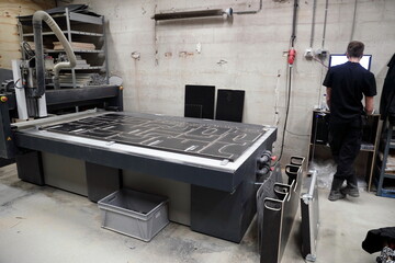 CNC machine in operation with worker in background managing flight case manufacturing processes