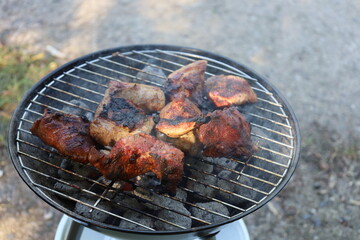 Grilled meat cooking over hot barbecue flames