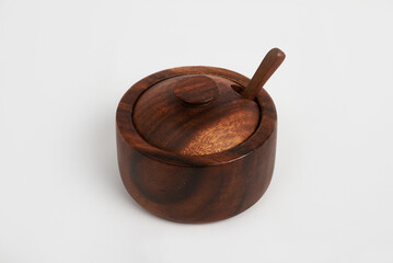 Wooden sugar bowl with spoon and lid on white background