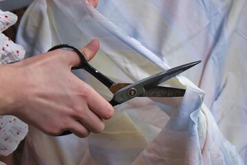 Woman cutting fabric ( side point of view close up)