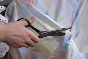 Woman cutting fabric ( side point of view close up)