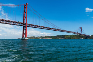 View of 25 de abril bridge from Tagus River in Lisbon Portugal during cloudy summer day