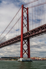 View of 25 de abril bridge from Tagus River in Lisbon Portugal during cloudy summer day