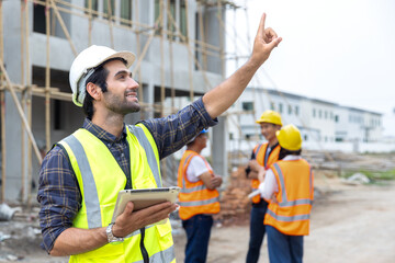 Foreman, engineer or architect with safety helmet holding laptop and blueprints for inspection...