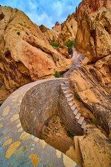 Obraz premium Stone Cistern and Stairs Among Red Rock Cliffs in a Desert Landscape