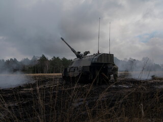Fototapeta premium PZH2000NL artillery piece positioned in smoky field with atmospheric conditions