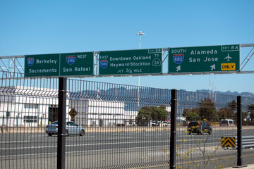 Freeway sign in the San Francisco Bay Area showing directions to Berkeley, Sacramento, Alameda, Downtown Oakland, and connections to Interstates 80 and 580.
