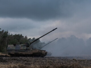PZH2000NL artillery piece positioned in field with smoke and overcast conditions