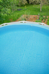 Frame pool with water for relaxing and swimming in the garden in summer.
