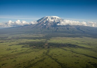 Fototapeta premium Aerial View of Mount Kilimanjaro Peak with Snow Cap and Lush Green Savanna Below