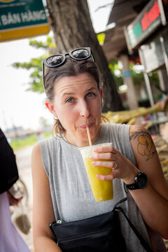 young woman drinking sugar cane juice in the Mekong Delta area of Vietnam