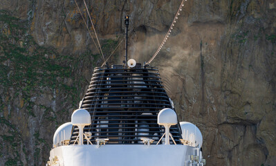 Ships funnel from cruise ship against steep rockface at Heimaey island Iceland