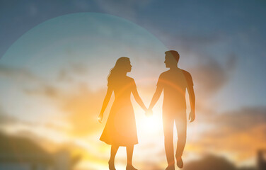 Silhouette couple holding hands walking at sunset