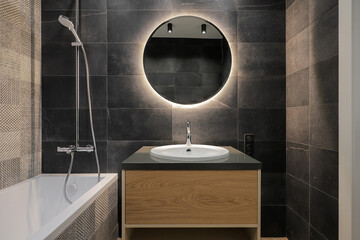 Faucet with sink and round mirror in the bathroom
