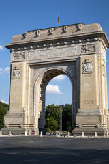 Obraz premium triumphal arch in bucharest, romania, standing as a historical monument and a symbol of national unity. the landmark is seen on a sunny day with a blue sky
