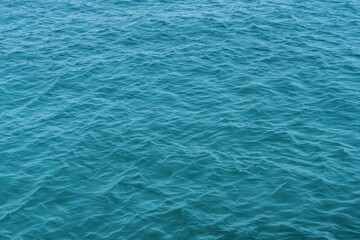 Gentle Ripples in Blue-Green Water. A serene image of the water's surface with gentle ripples and a blue-green color. Perfect for creating a calm and relaxing atmosphere, ideal for backgrounds.