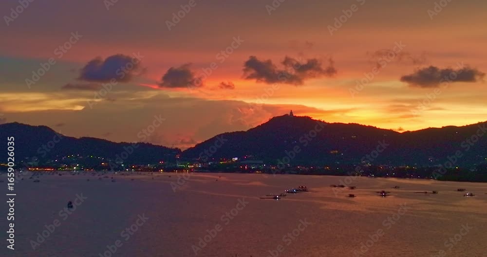 Wall mural aerial view of a tranquil sunset over a calm coastal landscape, with colorful sunset behind distant 