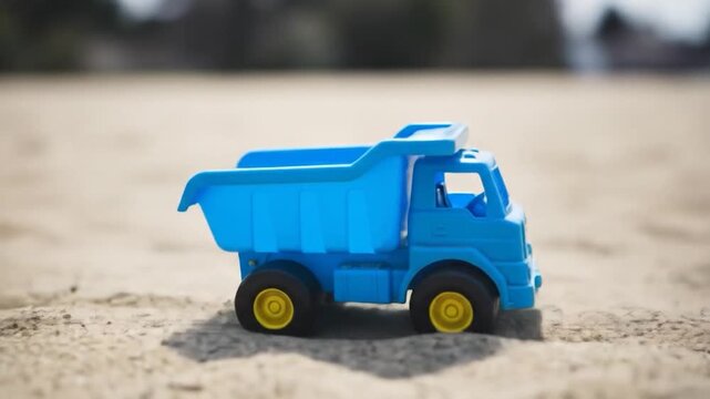 Blue Toy Dump Truck on Sandy Surface, Close-Up Shot, Sunny Day