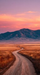 Serene sunset over a winding dirt road leading to distant mountains