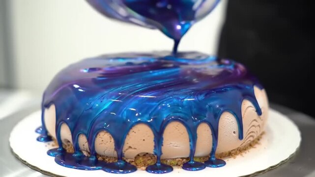 A visually stunning cake is being glazed with a vibrant blue icing