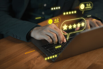 Customer typing on laptop computer with glowing 5 star review icons, symbolizing positive customer...