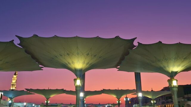 Static view of giant umbrellas of Nabawi mosque during early morning sunrise in Medina, Kingdom of Saudi Arabia.