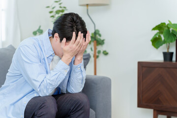 頭を抱えてうずくまる男性