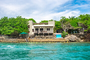 Breathtaking view of a modern house on Rosario Island, surrounded by lush greenery and turquoise...