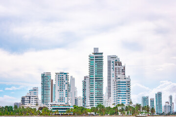 Fototapeta premium A stunning view of modern buildings against a cloudy sky in Cartagena's historic center, showcasing urban architecture and tropical landscape.