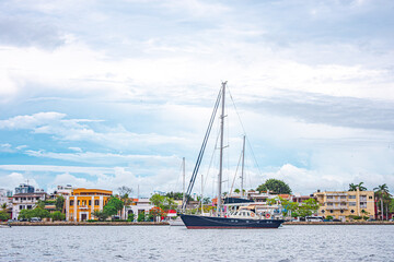 A picturesque sailboat floats in the calm waters of Cartagena, Colombia, showcasing the historic...