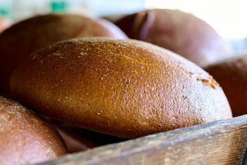 Freshly baked artisan bread rolls resting in a wooden basket at a local bakery during morning hours