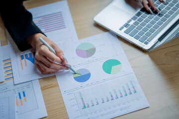 Business colleagues analyzing documents and charts at an office desk, focusing on planning, teamwork, financial analysis, cooperation, and decision-making.
