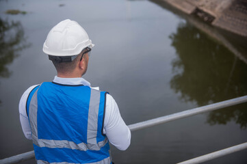 A skilled architect is seriously constructing a major structure for a large river gate.