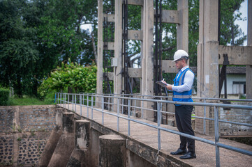 A specialist engineer is inspecting the operation of a water gate in a large river.