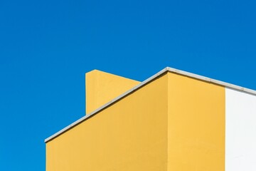 Yellow and White Minimalist Building Corner Against a Blue Sky