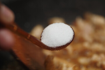 Cooking in the kitchen with sugar and wooden spoon