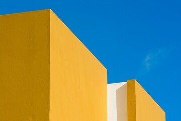 Golden Yellow and White Geometric Building Against a Blue Sky