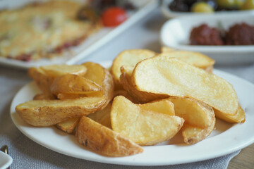 Crispy golden potato wedges on a white plate