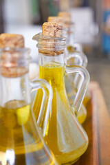 Fresh olive oil displayed in unique glass bottles at market