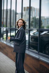 Fototapeta premium The model is a student girl, young and beautiful in a business suit on the street outside the building