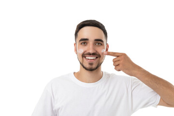 Young man applies moisturizer on his face happily, isolated, PNG