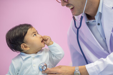Mail pediatrician doctor in white cost gown hold stethoscope exam child infant patient. pediatrician sitting seduce misbehave baby infant for stethoscope checkup in hospital children medical care