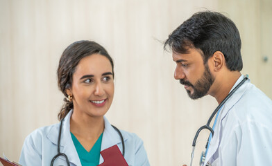 Two doctor hold clipboard document file of patient record talking discussion about treatment guidelines. Doctor surgeon advice assistance expertise.