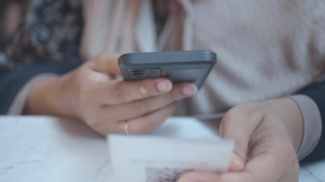  woman using a mobile device to scan QR code for cafe menu 