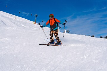 Action shot of a skier racing down a snow-covered slope in the stunning Austrian Alps. Experience the thrill of winter sports in Tyrol, Austria, a paradise for outdoor enthusiasts.