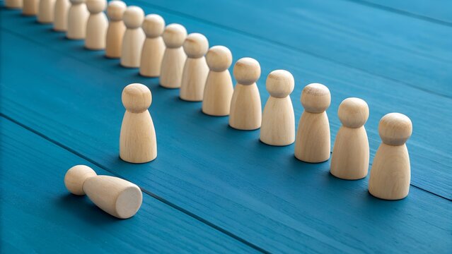 Social Exclusion and Individual Vulnerability Concept – Wooden Figurines in Line on Blue Surface, One Lying Down Apart from Group, Isolation Symbolism, Mental Health Awareness, Workplace Alienation, E