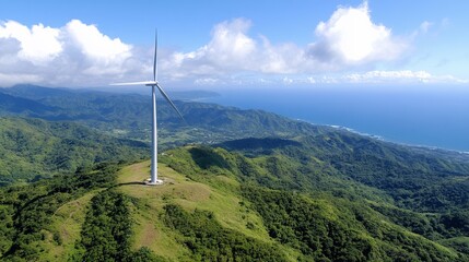 High-angle view of a wind turbine atop a lush mountain, overlooking a coastline