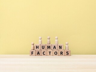 Human Factors text on wooden block , symbolizing psychology, ergonomics, workplace safety, decision-making, and human-centered design.