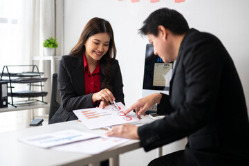 Business people analyzing charts and graphs, discussing financial results in office