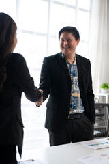 Business people shaking hands in modern office after successful meeting